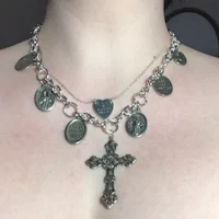 a woman is wearing a necklace with a cross and other charms