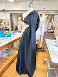 a black dress on a mannequin in a sewing room
